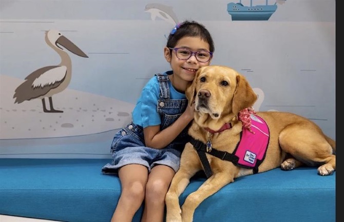 Patient April visits with Millie, chief snuggle officer at Muma Children's Hospital at TGH