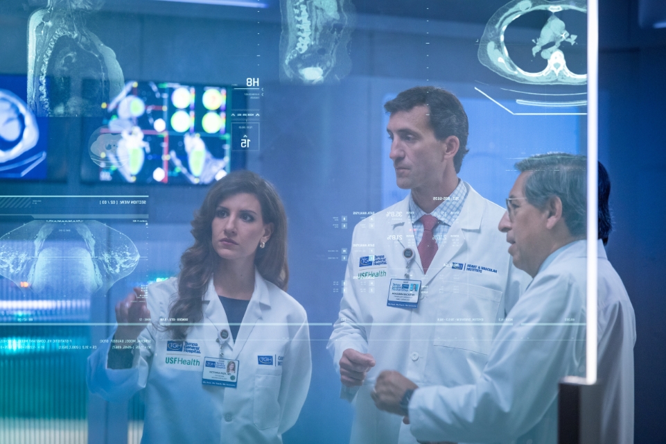academic health system image featuring tgh physicians Dr. Sotomayor, Dr. Mackie and Dr. Rizk reviewing images and metrics in a futuristic medical setting
