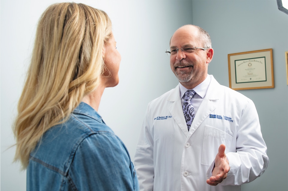 dr hechtman of tgh cancer institute speaks with a female patient in his office