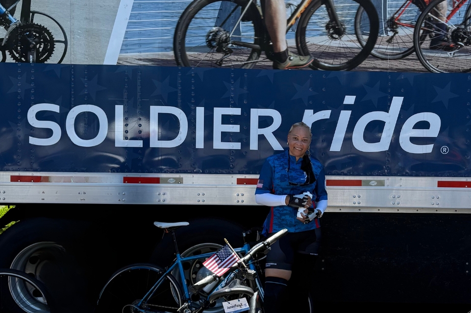 tampa general lymphedema patient monica stands with her bicycle in front of a soldier ride display