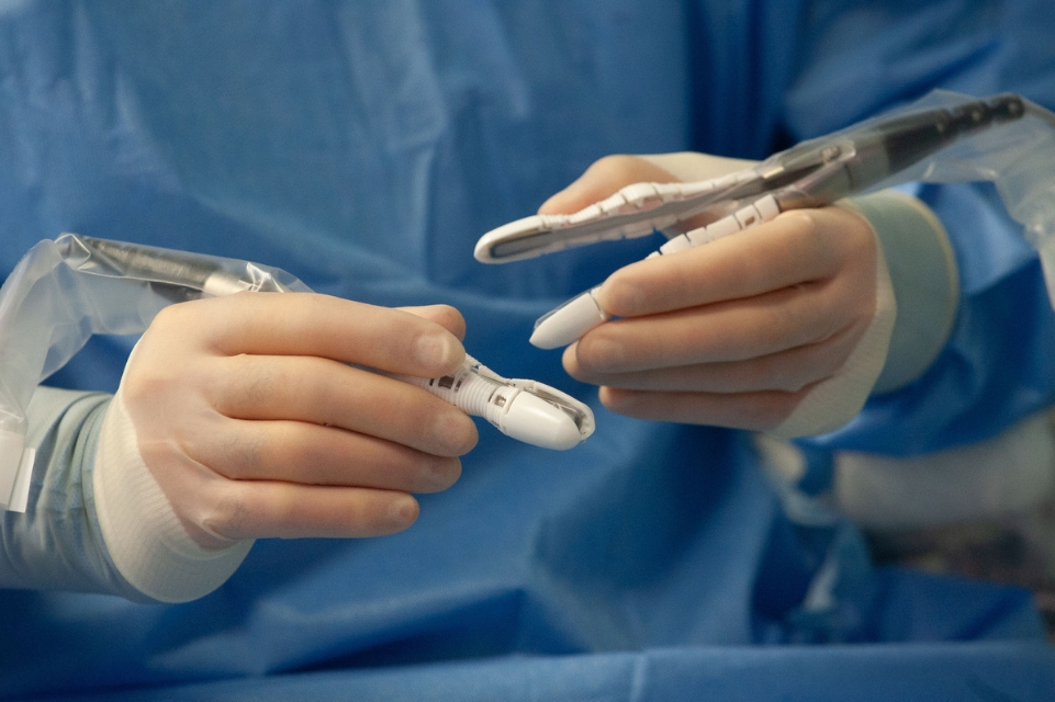 closeup image of dr. nicholas panetta's hands using tools connected to symani surgical system