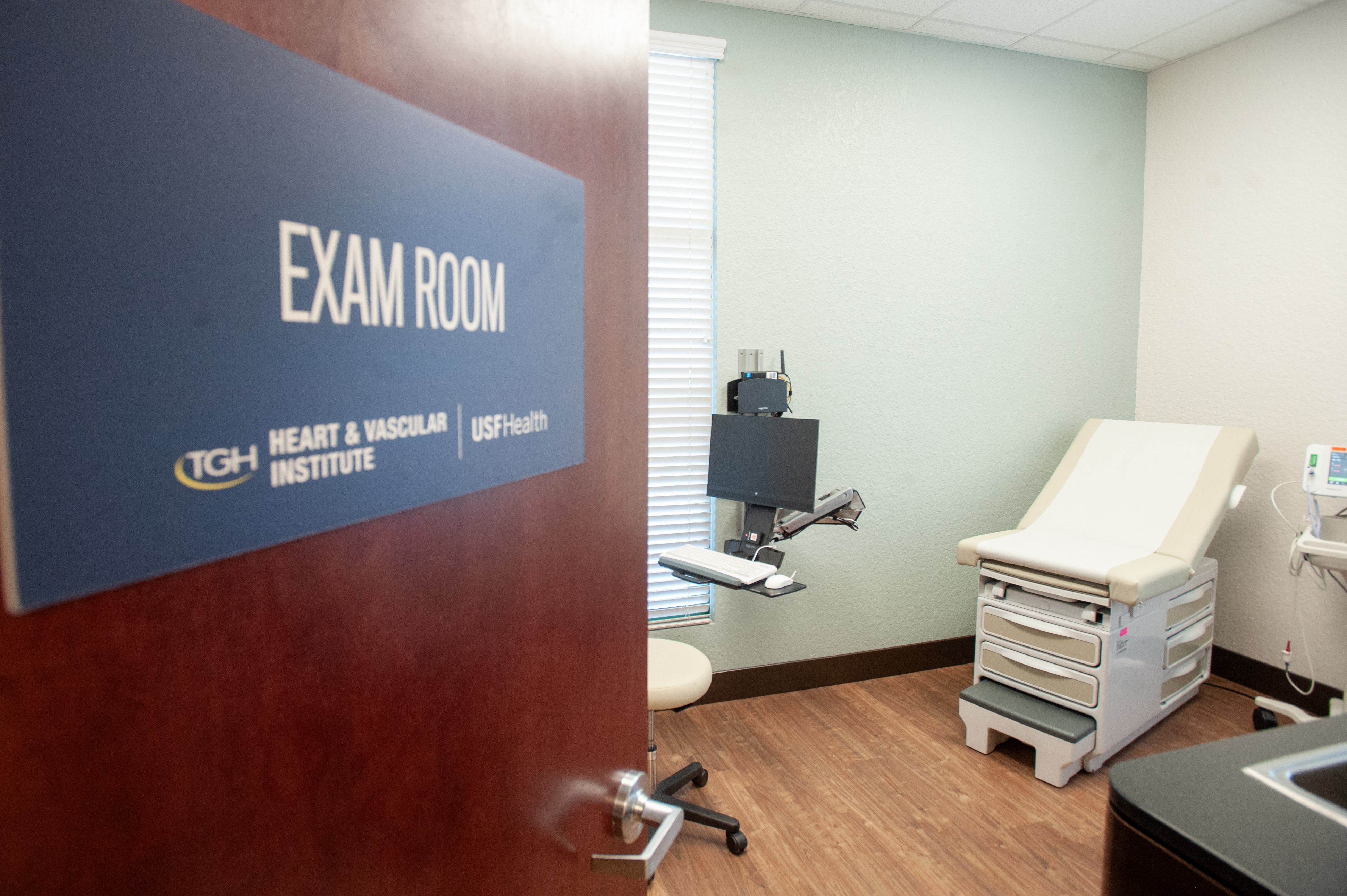 patient exam room at the tampa general hospital-usf health heart and vascular institute sun city clinic with signage and medical equipment