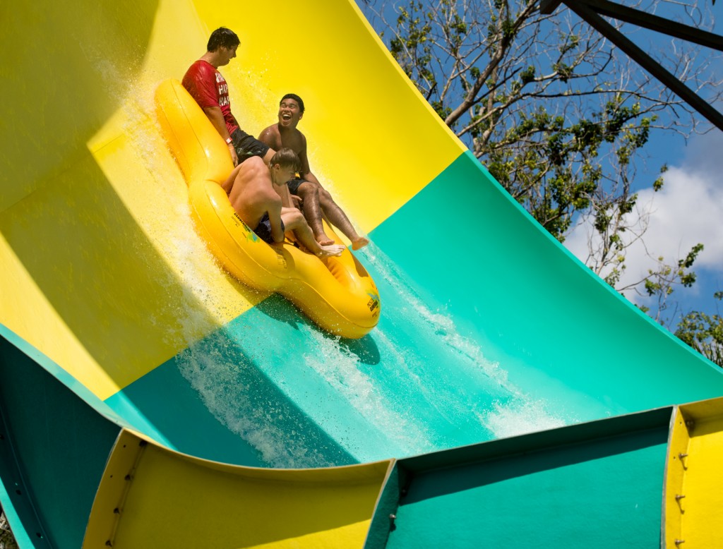 Parker Benz, Angel Cruz, and Kristoff Sempf, sail down the Colossal Curl at Adventure Island