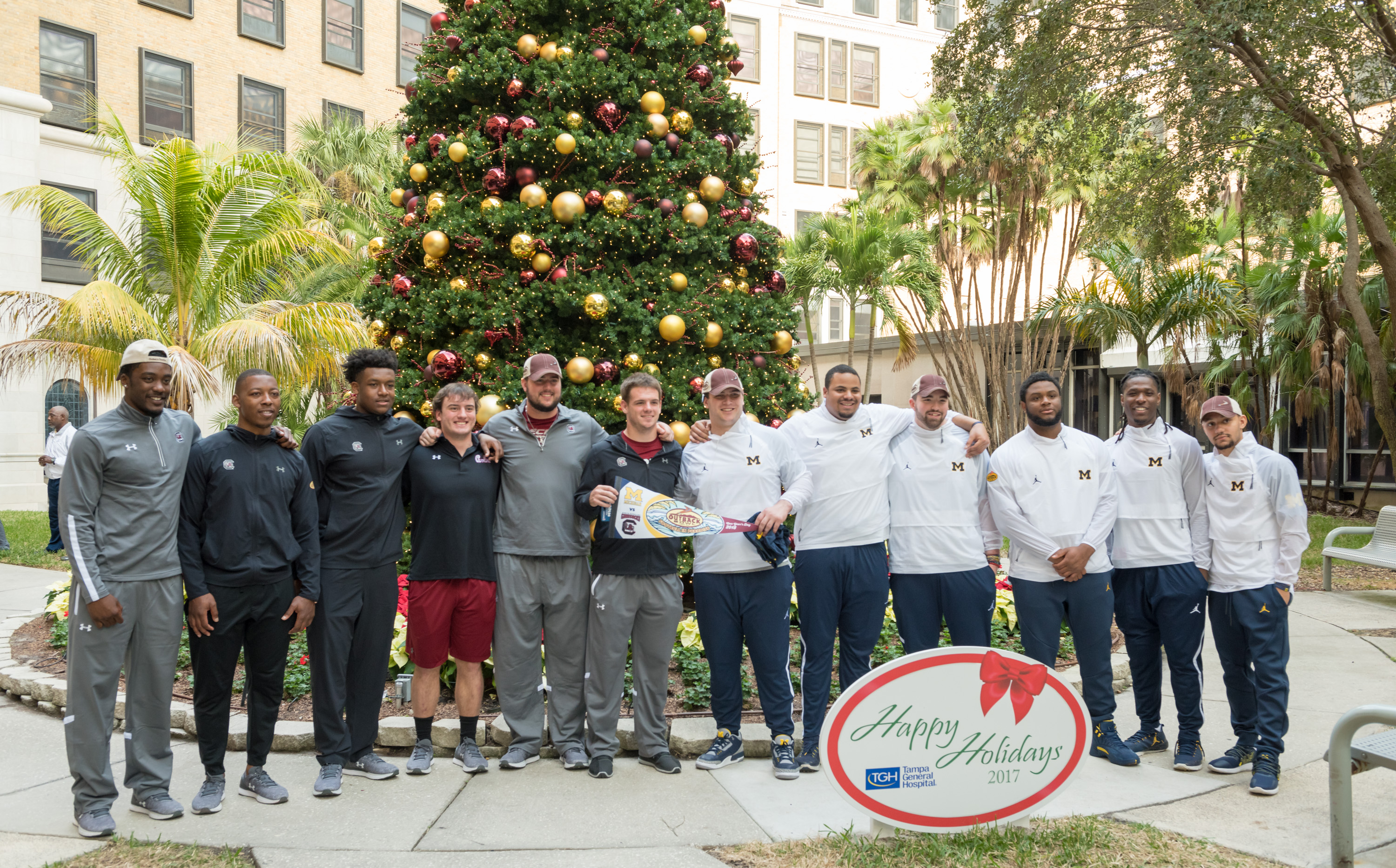 Outback bowl players in front of the Christmas tree