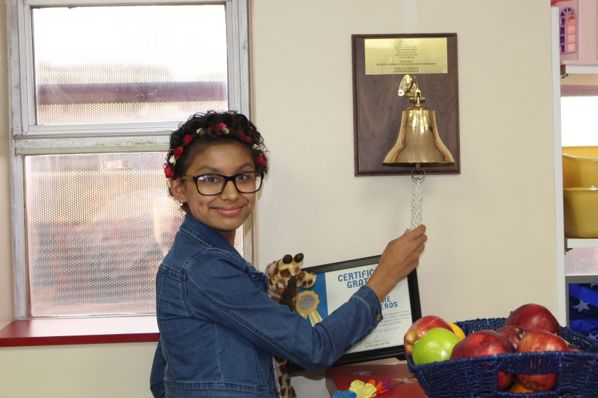 Teen girl ringing the chemo bell