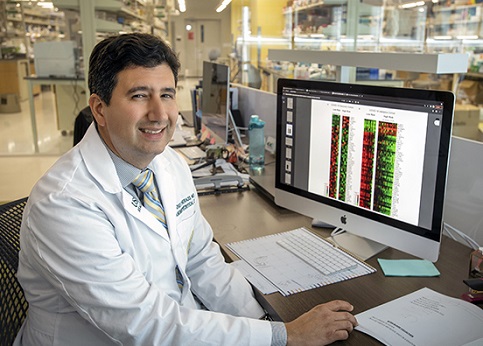 Dr. Jose Herazo-Maya sitting at a computer examining test results