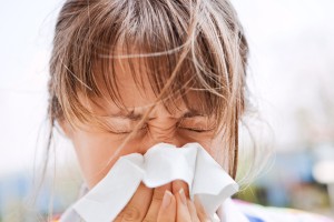 Woman with allergies blows her nose