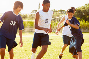 Teens kicking a soccer ball around