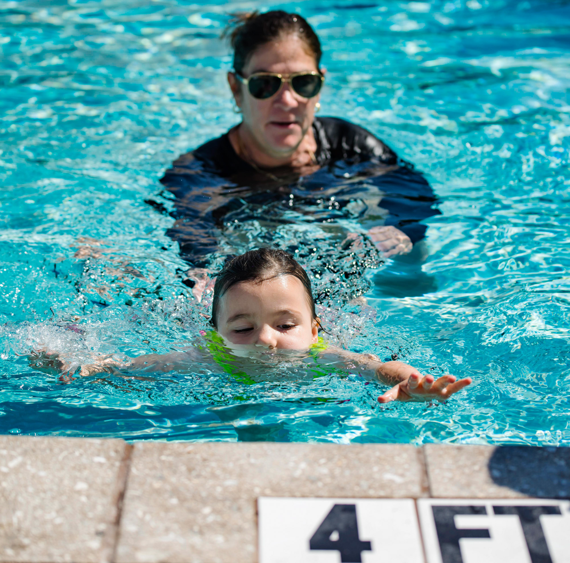 Woman teaching a young girl how to swim