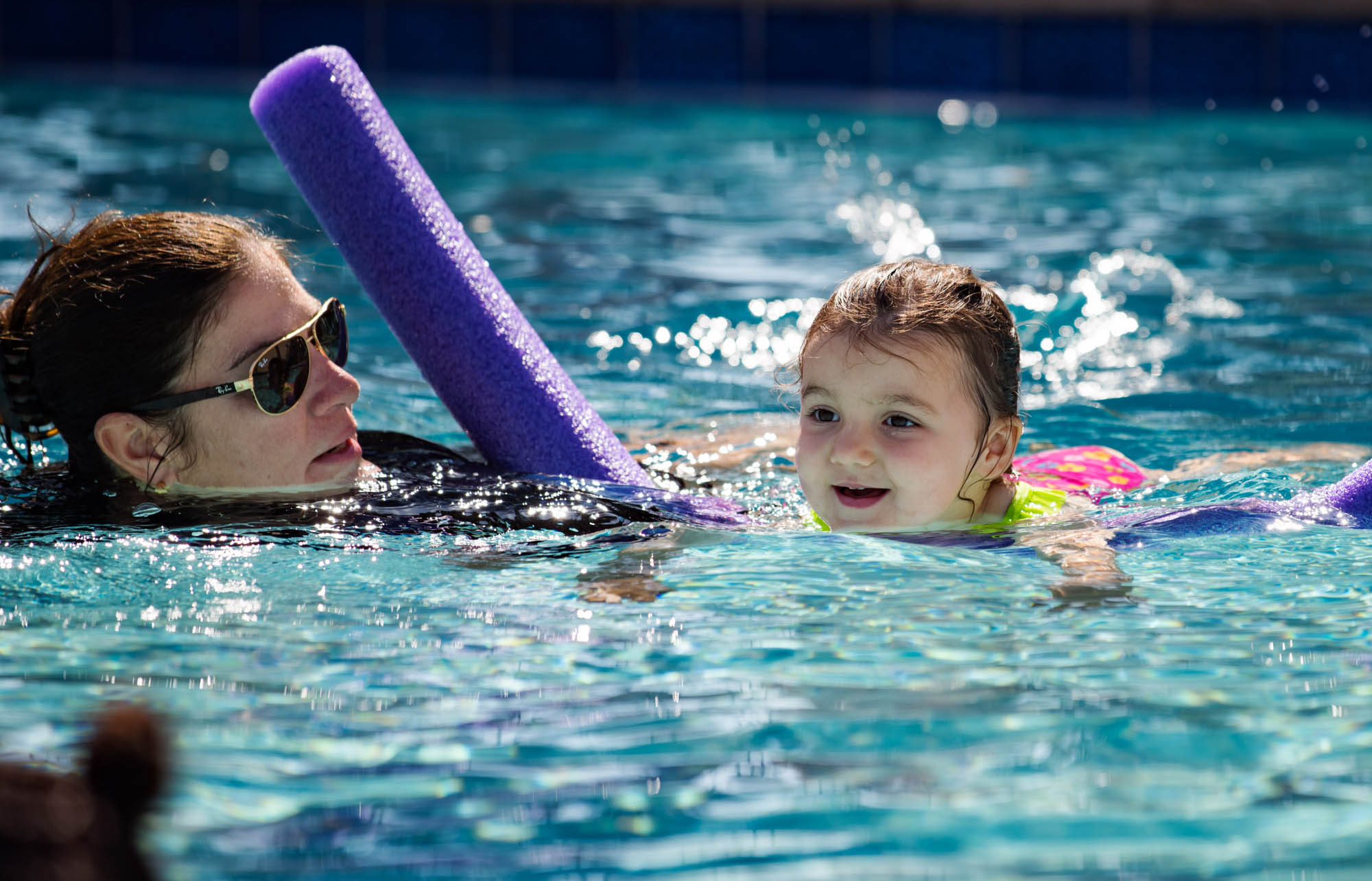 Woman teaching a young girl how to swim