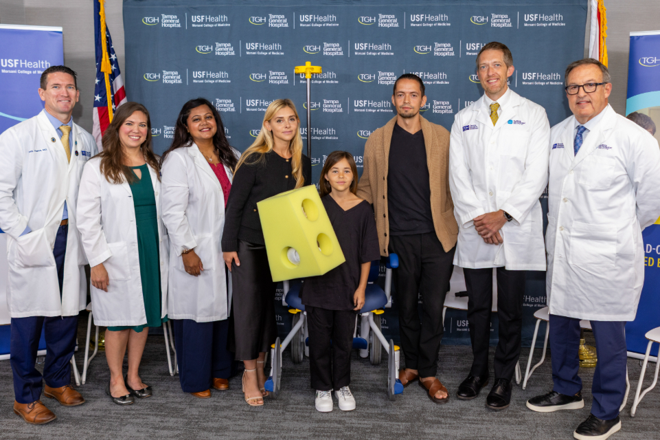 leah lendel and her family pose with her tgh care team at press conference to discuss her shark bite survival story