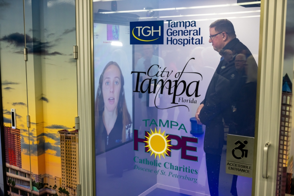 a catholic charities employee inside the onmed mobile clinic meeting with a provider virtually on a monitor