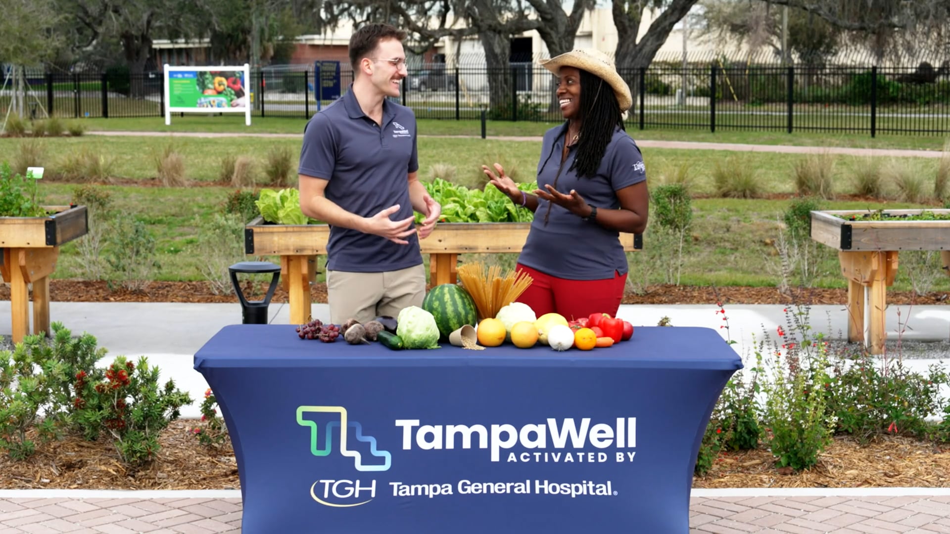 thumbnail for colorful foods video featuring tampawell team members behind a table of food at the tampawell community garden