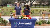 thumbnail for red foods video featuring tampawell team members behind a table of red foods at the tampawell community garden