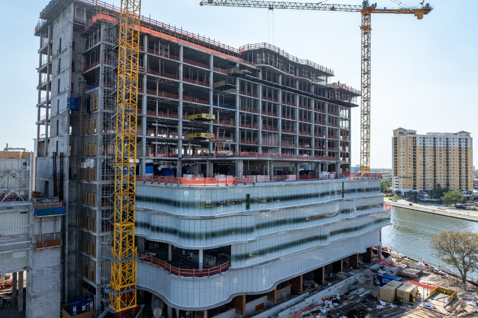 tgh Taneja Surgical, Neuroscience & Transplant Tower under construction with cranes, waterway, and building in background