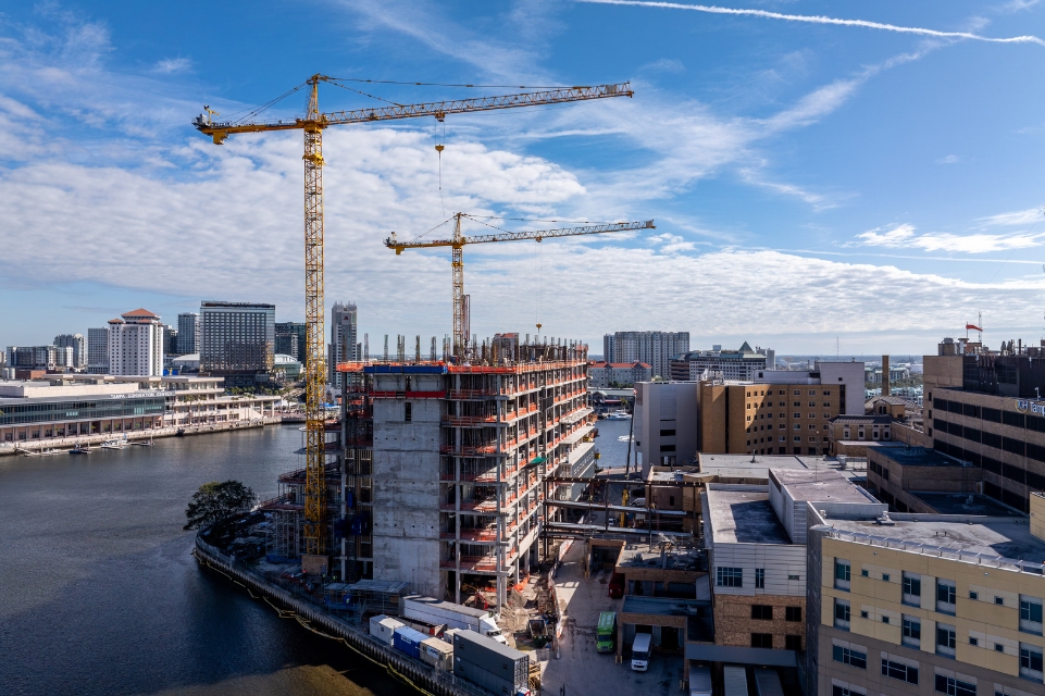 side view of the TGH Taneja Surgical, Neuroscience & Transplant Tower under construction with TGH Davis Islands campus in foreground and Harbor Island in background