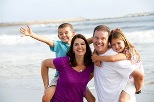 familj poserar för kameran på stranden
